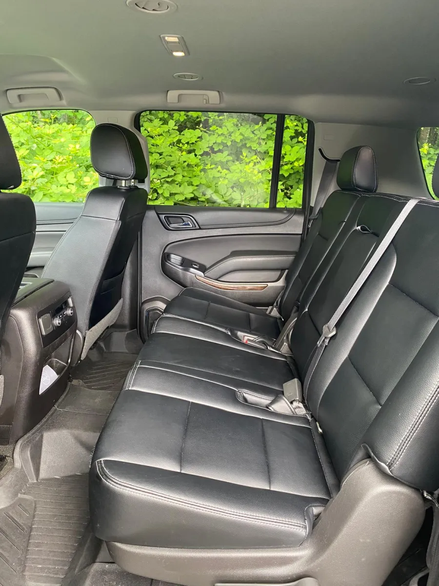Black leather rear passenger seats and seatbelts inside an SUV