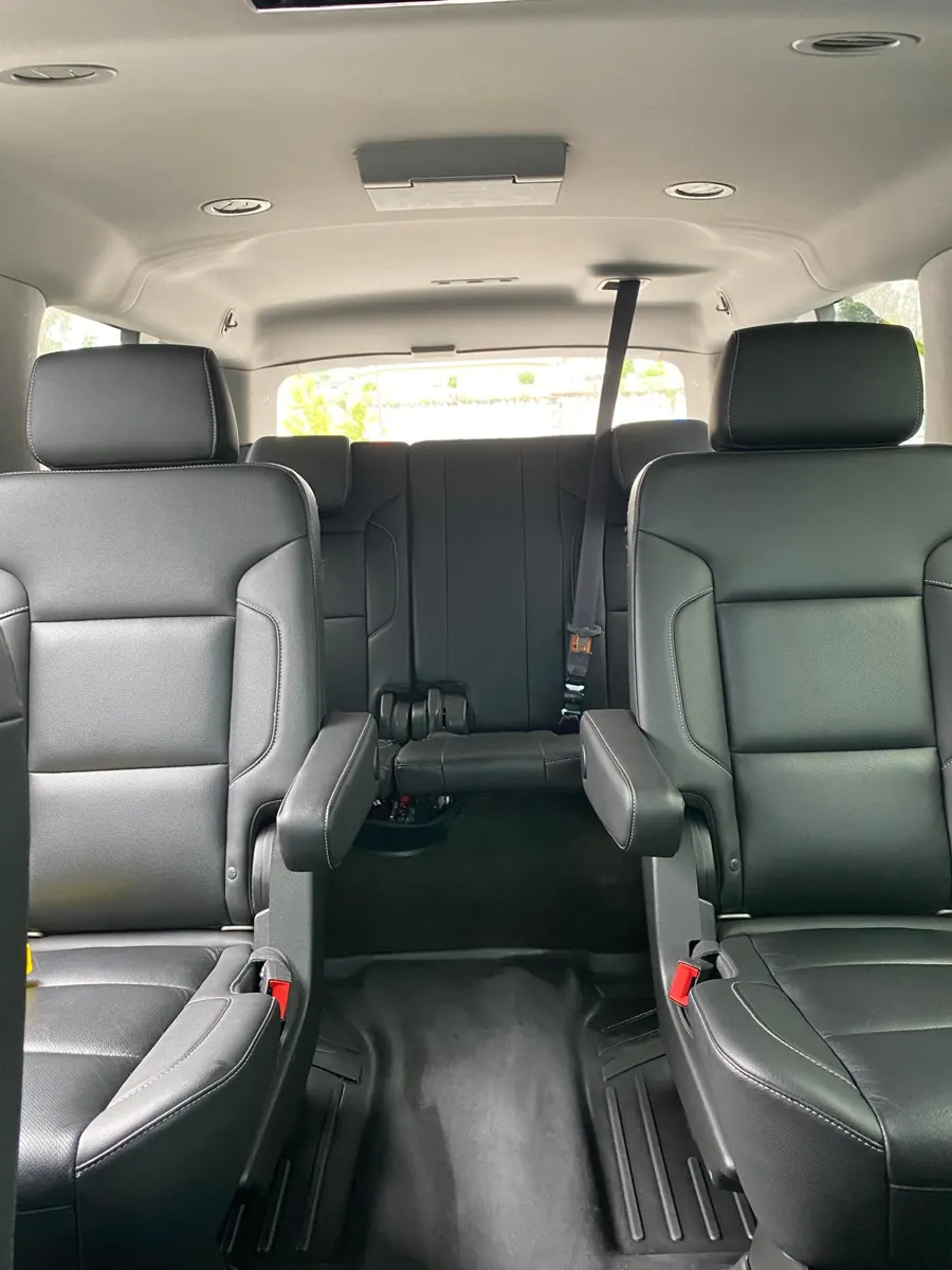 Black leather passenger seats with a centre aisle and rear bench inside an SUV